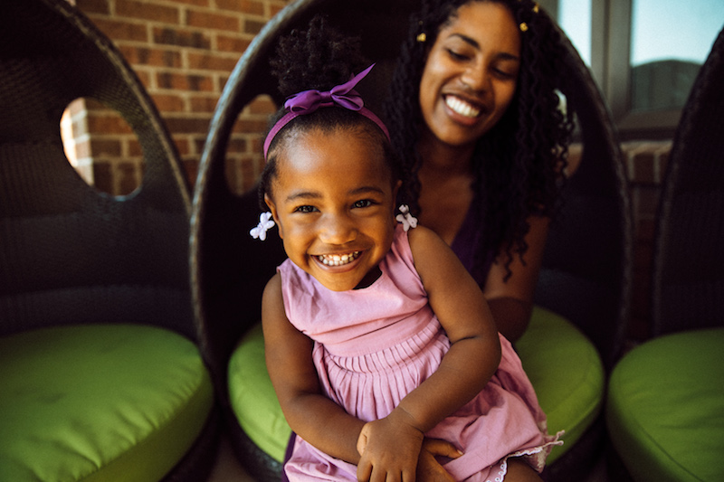 little girl sitting on women's lap