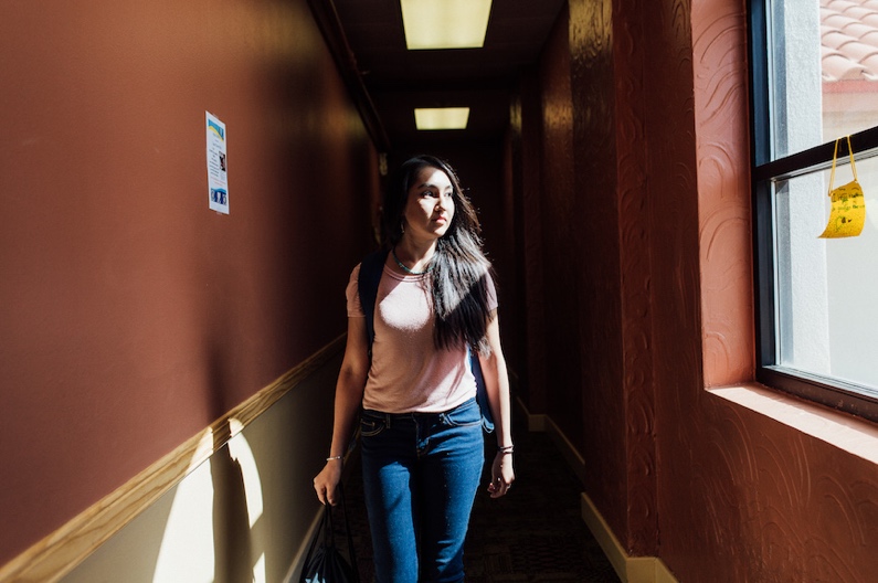 women walking down a sun lit hallway